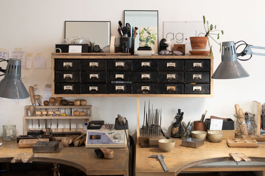 Atelier de bijoutier créateur à Paris – établi en bois avec outils de joaillerie, lampes de travail et rangements, lieu de fabrication artisanale de bijoux faits main en argent et vermeil.