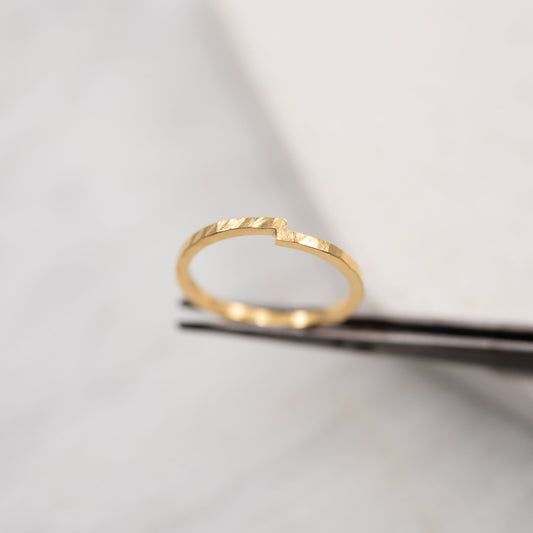 Close-up of a handmade jewelry vermeil gold ring on a white marble background - minimalist design, crafted in Paris.