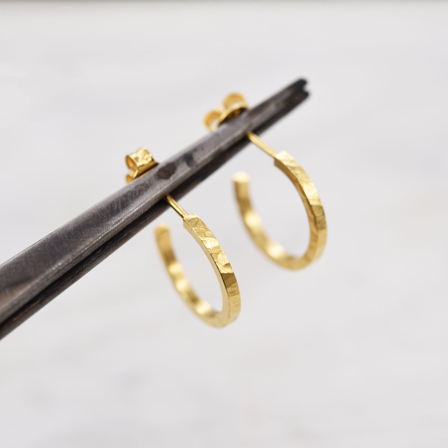 Boucles d’oreilles créoles en vermeil martelé faites main, design minimaliste et moderne, bijoux artisanaux durables fabriqués à Paris pour un usage quotidien.
