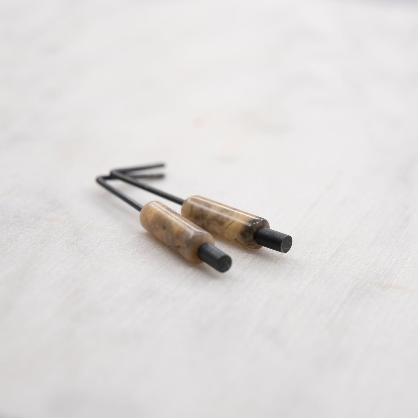 Boucles d’oreilles en argent oxydé et agate crazy posées sur fond clair – bijou minimaliste fait main à Paris, création artisanale contemporaine.