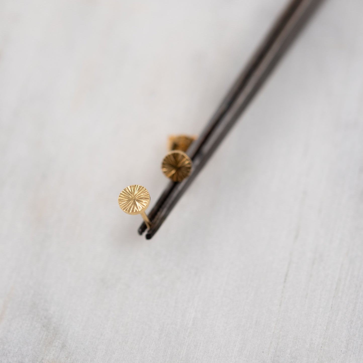 Gros plan détaillé d’une boucle d’oreille clou en vermeil or gravé – bijou talisman minimaliste de Paris