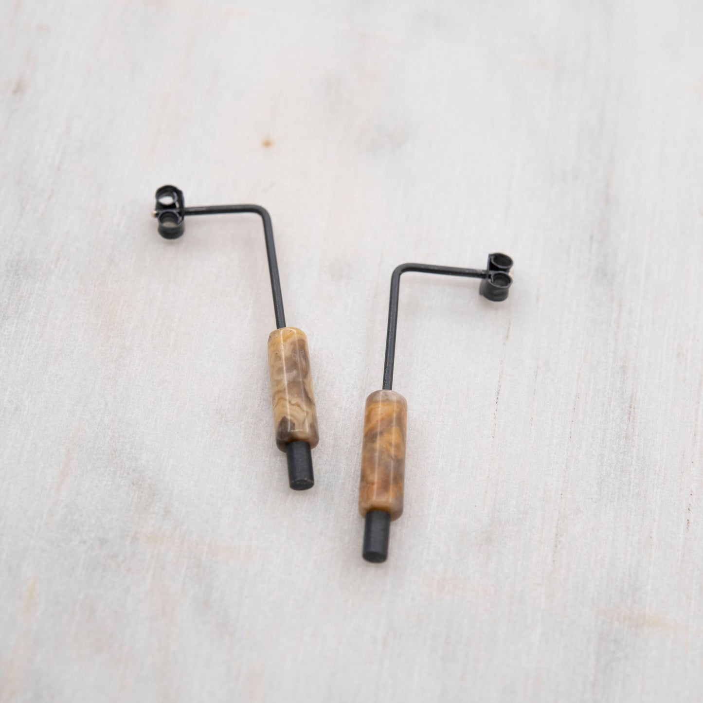 Boucles d’oreilles pendantes en argent oxydé et agate crazy, bijou minimaliste fait main, photographié sur fond neutre – création artisanale par un bijoutier à Paris.