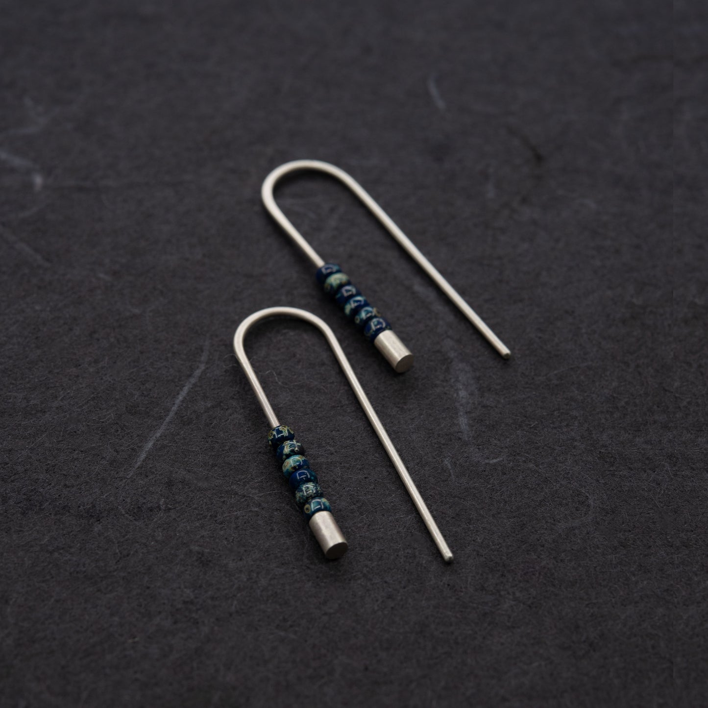 Boucles d’oreilles contemporaines en argent avec finition mate et perles Miyuki bleu profond.