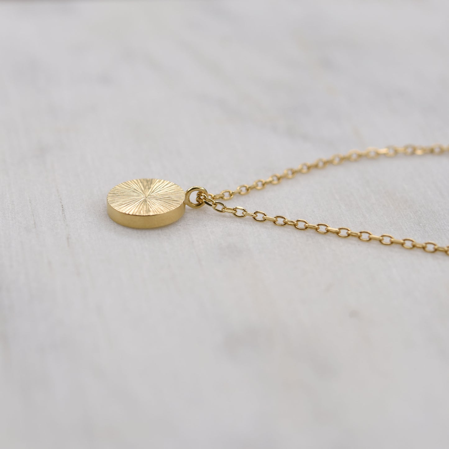Vue de côté collier pendentif éclat de soleil en or, bijou minimaliste artisanal de Paris