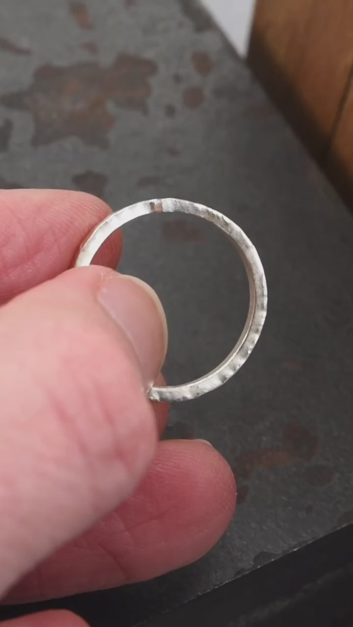 Vidéo présentant un anneau en argent sterling martelé, mettant en valeur son design unique et minimaliste avec un détail d’encoche distinctive qui symbolise l’union de deux éléments. La vidéo montre les détails du travail artisanal, avec des vues rapprochées de la texture martelée et de la forme de l'anneau, idéal comme alliance, bague de fiançailles ou accessoire quotidien.