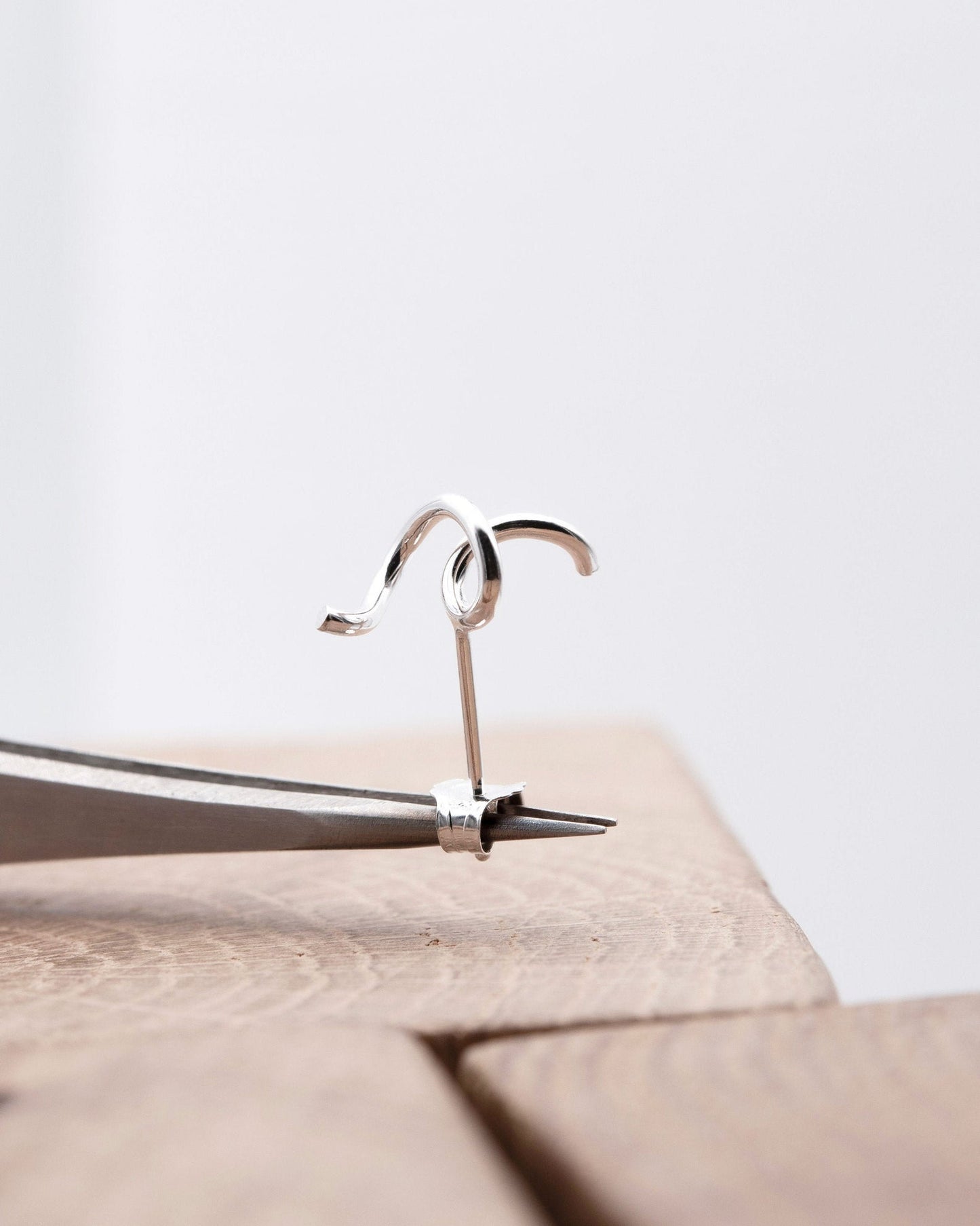 The abstract single earring is twisted by hand from silver by AgJc