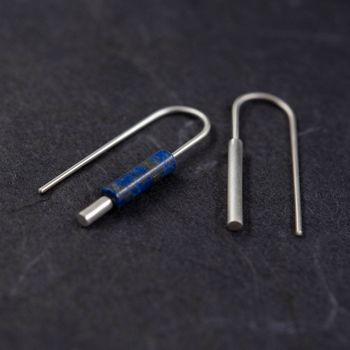 Paire de boucles d’oreilles dépareillées en argent 925 avec détail cylindrique en lapis-lazuli.