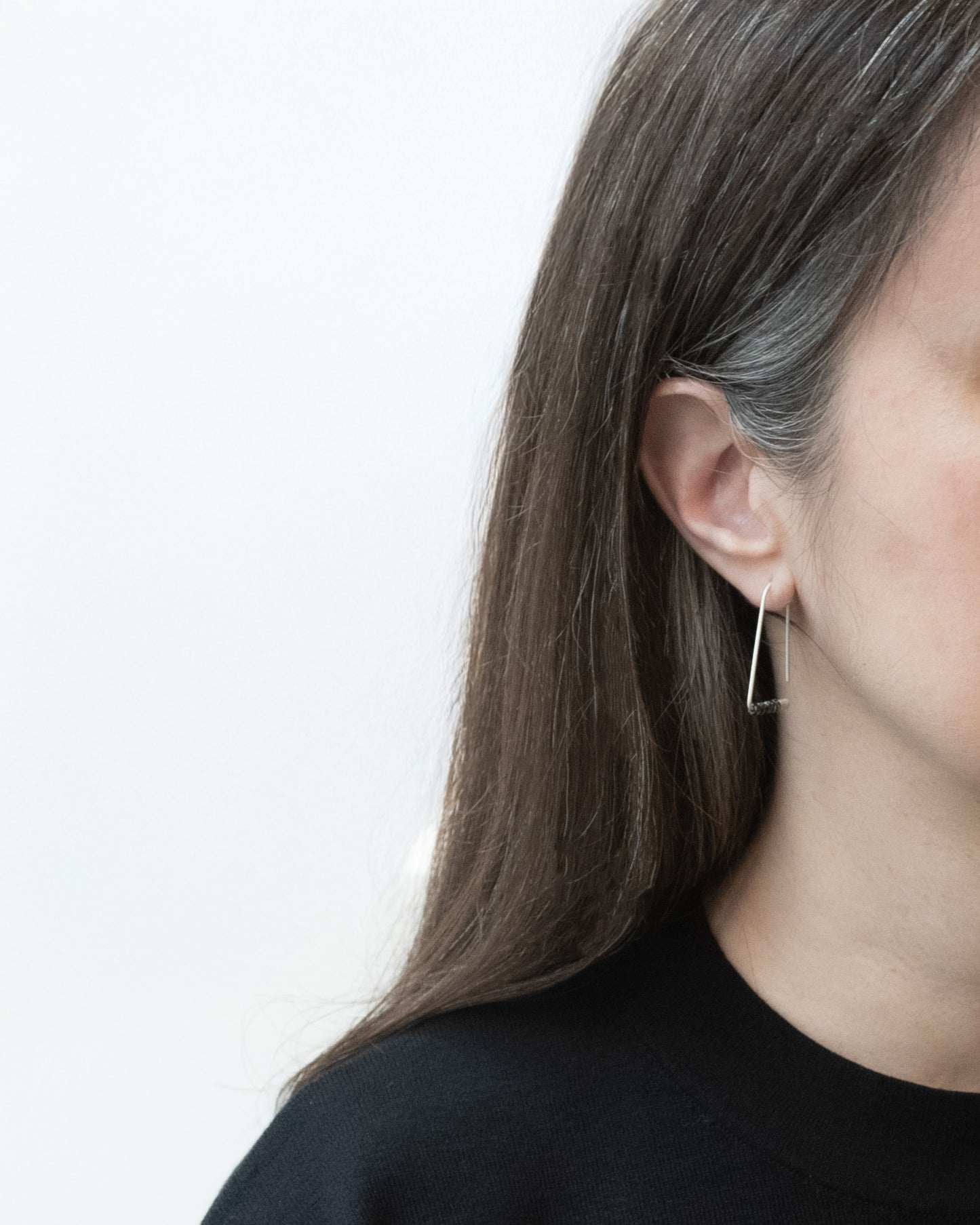 Premier plan d'une femme portant des Boucles d’oreilles triangulaires minimalistes en argent sterling avec perles Miyuki
