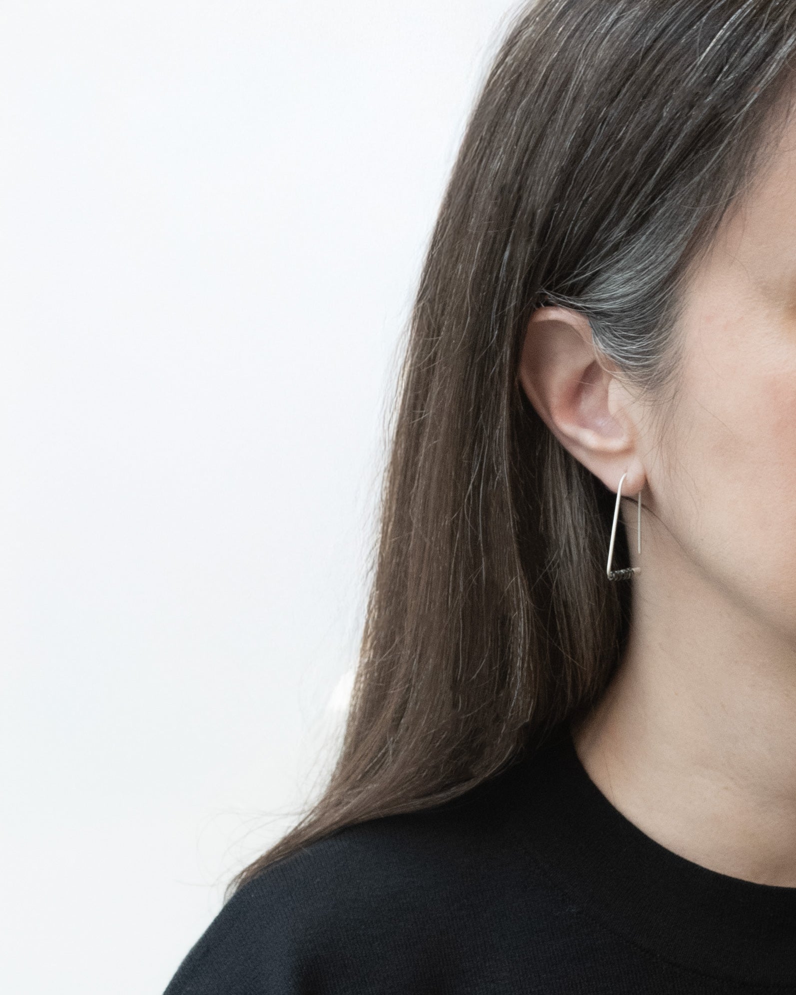 Premier plan d'une femme portant des Boucles d’oreilles triangulaires minimalistes en argent sterling avec perles Miyuki
