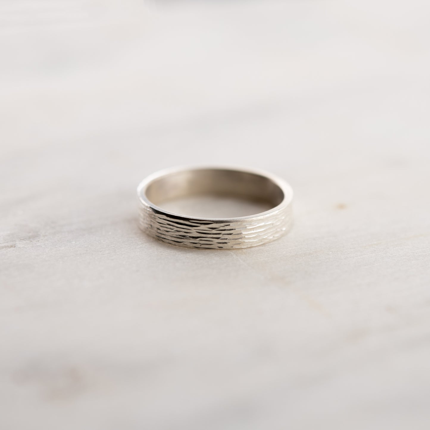 Vue de face de la bague Étincelles en argent montrant la texture gravée sur fond clair.