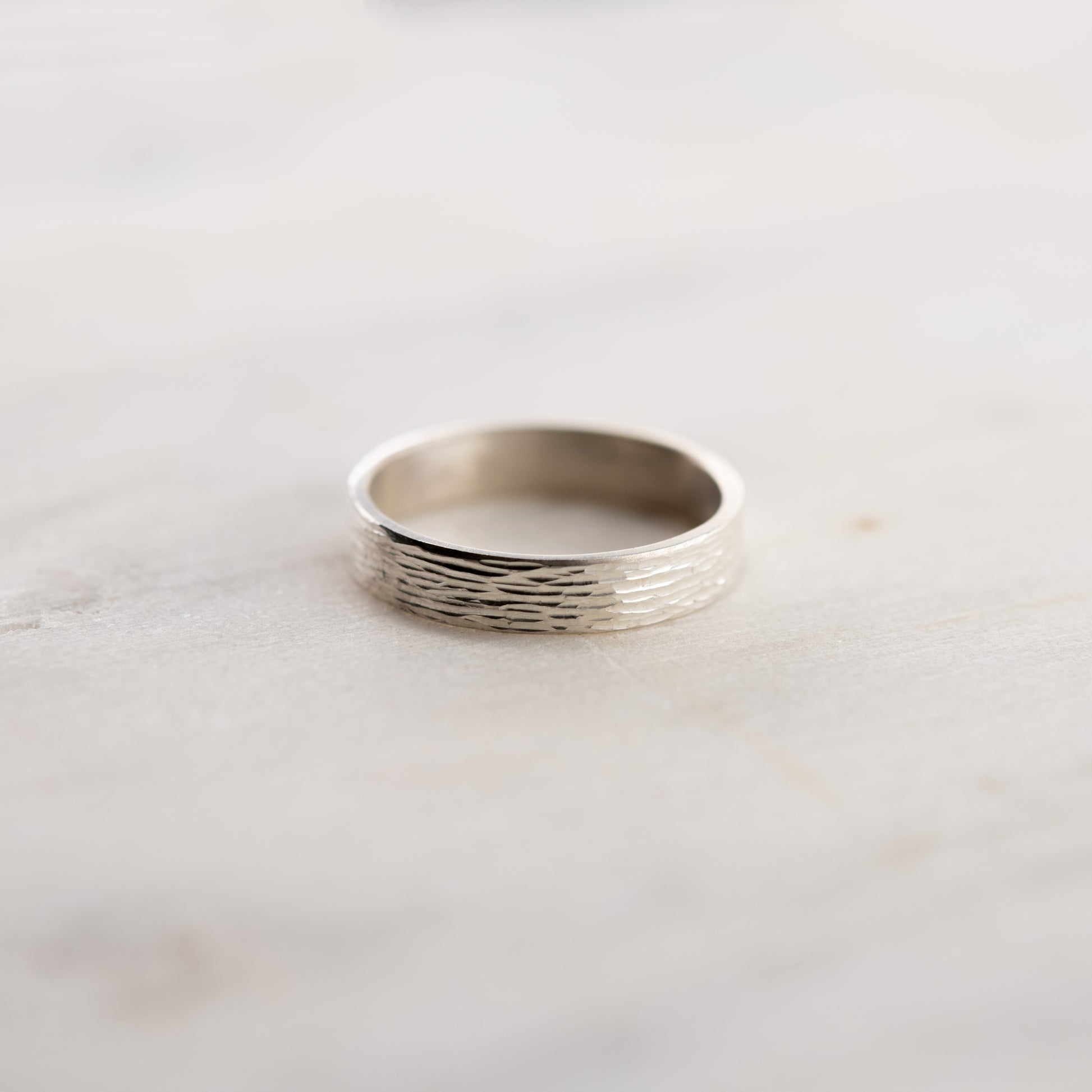 Vue de face de la bague Étincelles en argent montrant la texture gravée sur fond clair.