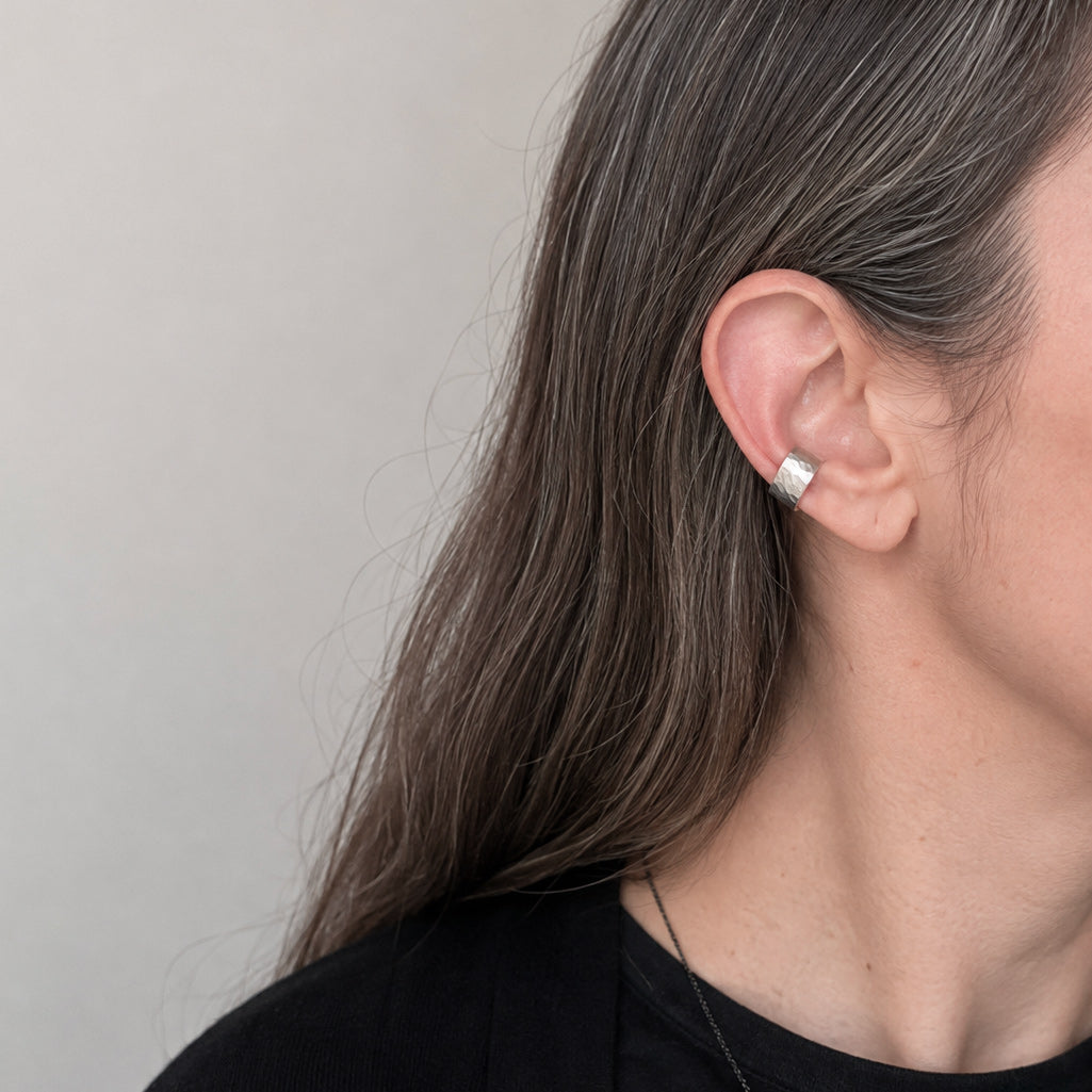 Vue portée de la bague d’oreille en argent massif martelé, texture artisanale sur l’oreille