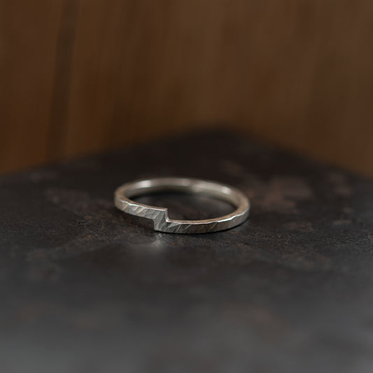 Bague en argent sterling faite à la main, symbolisant l'union de deux éléments. Son design unique présente deux extrémités qui se rejoignent, incarnant la connexion et l'harmonie. Fabriquée à partir d'un fil carré de 1,5 mm avec une texture martelée et un détail en encoche, cette bague minimaliste est idéale comme alliance, bague de fiançailles ou accessoire quotidien plein de sens. Une pièce moderne et intemporelle, façonnée et polie à la main pour une touche unique et personnelle.