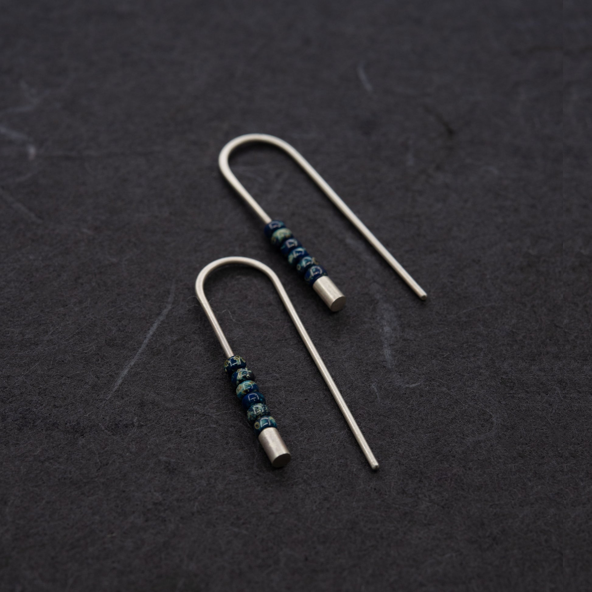 Boucles d’oreilles contemporaines en argent avec finition mate et perles Miyuki bleu profond.