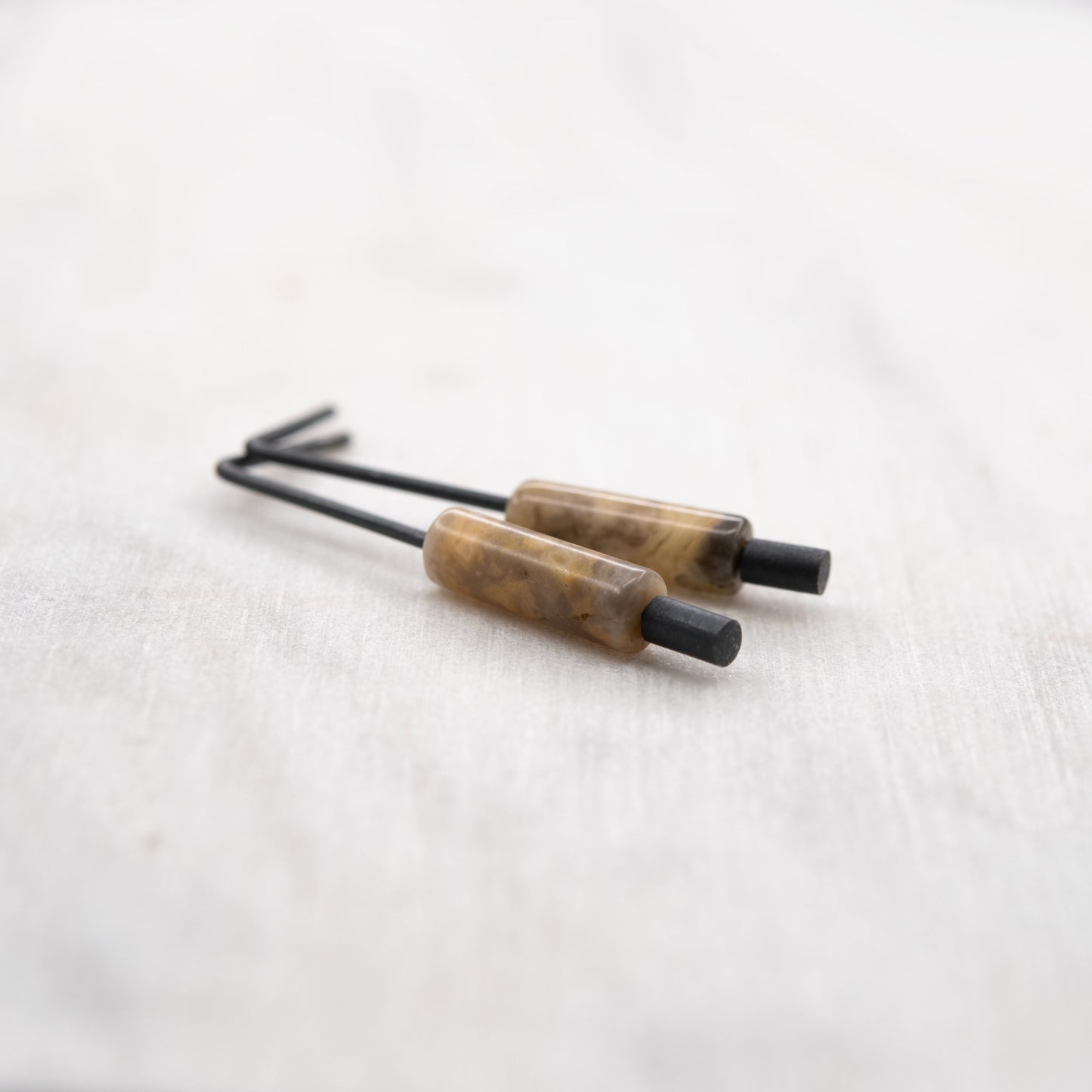 Gros plan d’une boucle d’oreille en argent oxydé avec pierre naturelle d’agate crazy – bijou créateur au style minimaliste, fabriqué à la main à Paris.
