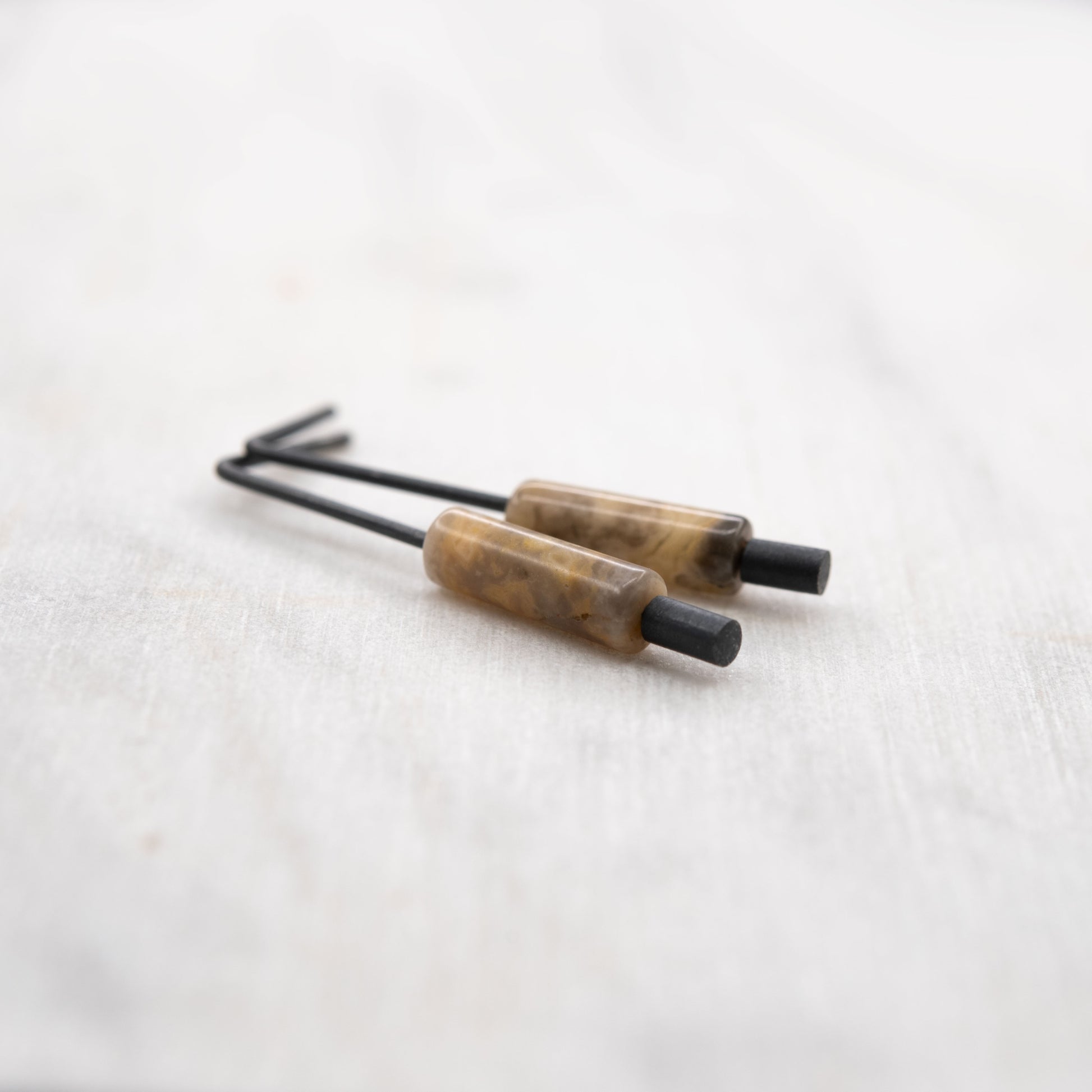 Gros plan d’une boucle d’oreille en argent oxydé avec pierre naturelle d’agate crazy – bijou créateur au style minimaliste, fabriqué à la main à Paris.