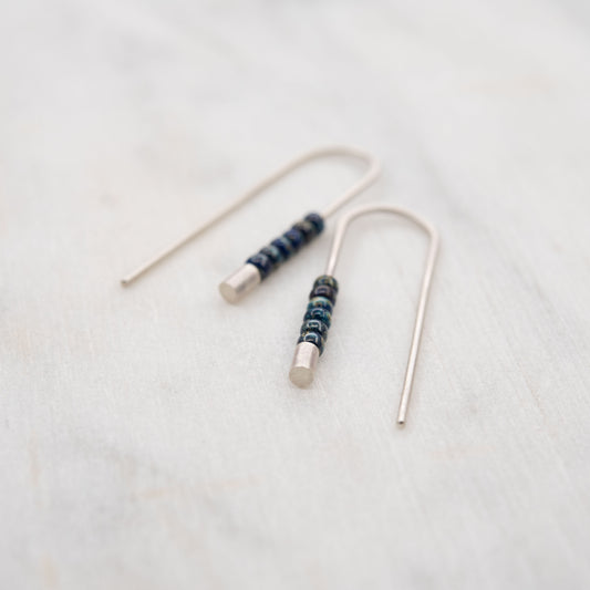 Boucles d’oreilles minimalistes en argent massif avec perles Miyuki bleues et finition mate, présentées sur fond clair.