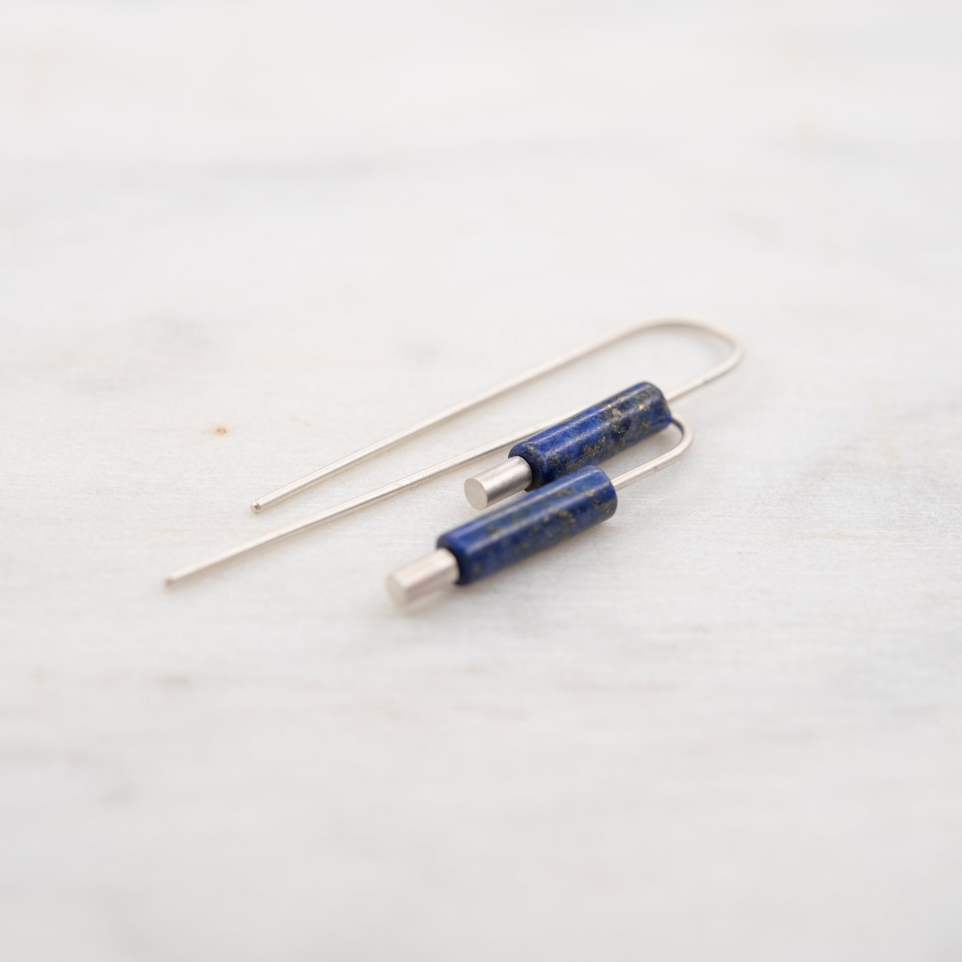 vue proche des boucles oreilles argent lapis lazuli pendantes minimalistes sur fond clair