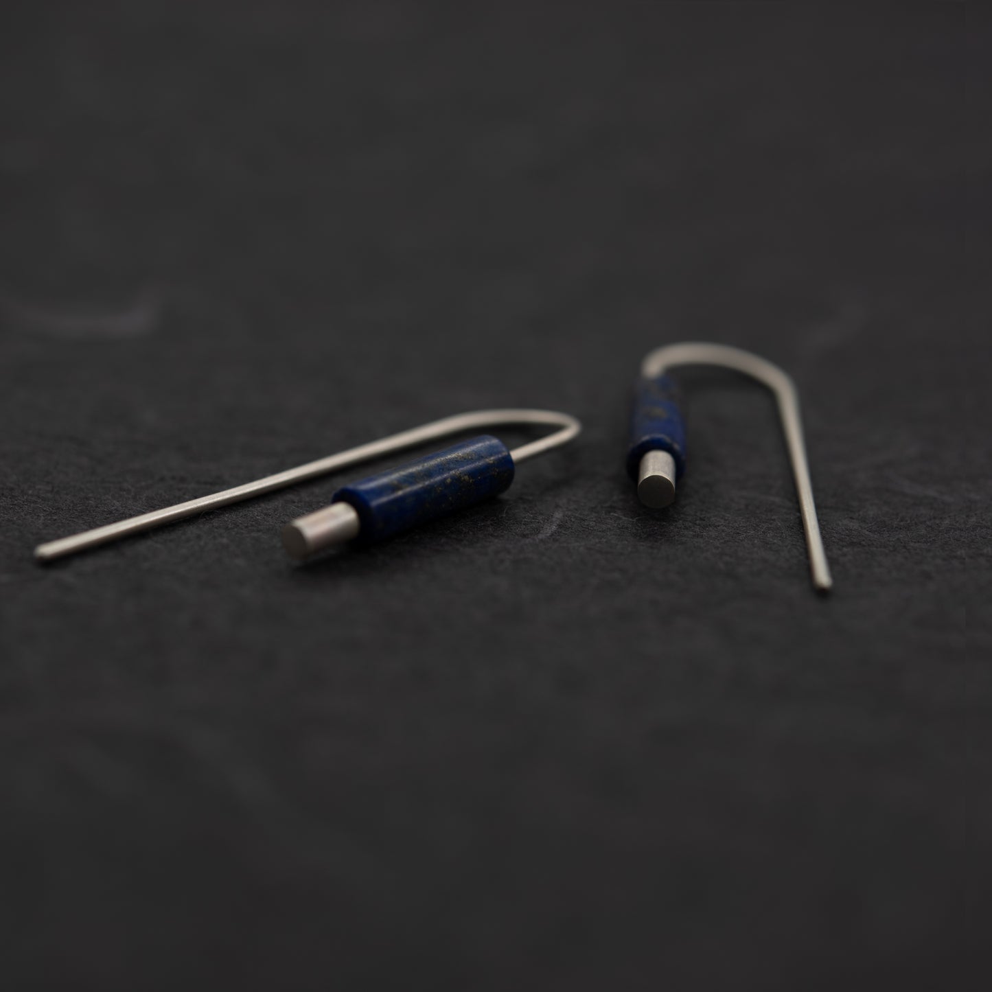 vue de prés des boucles oreilles artisanales argent pierre bleue lapis lazuli sur fond sombre