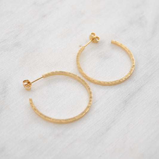 Grandes créoles martelées en vermeil doré à l’or 24k sur un fond claire. faites main à Paris – AgJc