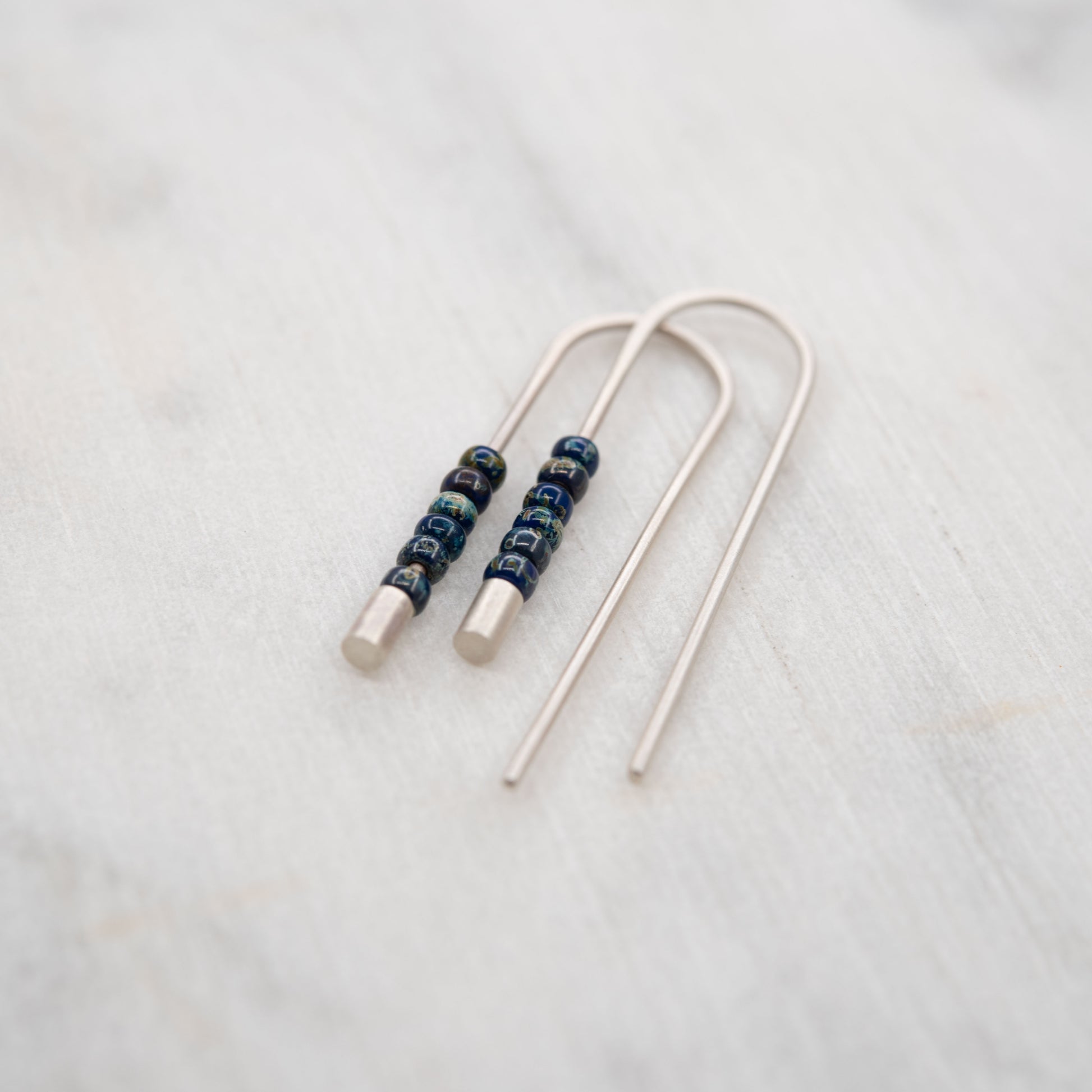 Paire de boucles d’oreilles longues en argent avec perles de verre Miyuki bleu foncé, design moderne et artisanal.