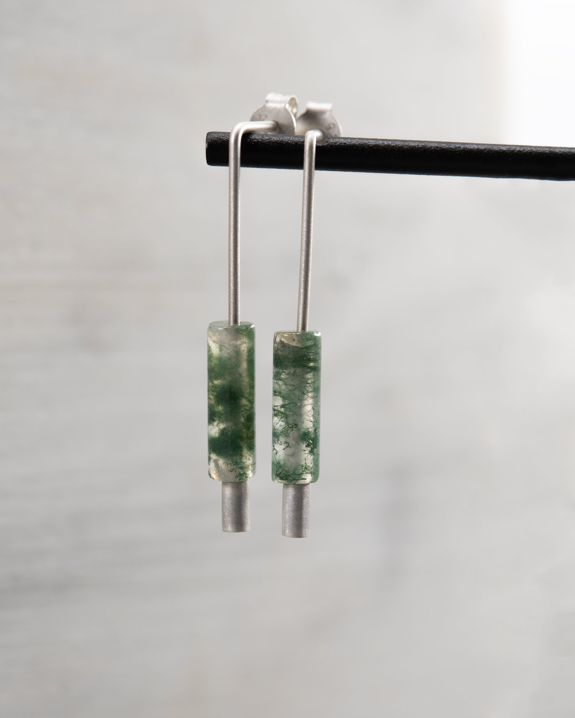 Detail view of handmade sterling silver and moss agate earrings