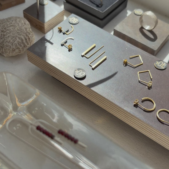 Vidéo présentant les boucles d’oreilles traversantes en argent massif 925 brossé et perles rouges Miyuki, vues en détail puis portées à l’oreille.