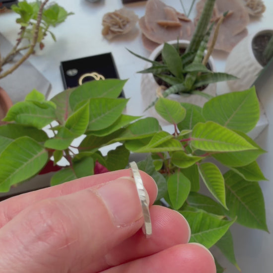 Vidéo d'une bague martelée fine en argent massif 925 tournée à la main pour révéler sa texture facettée et ses reflets.