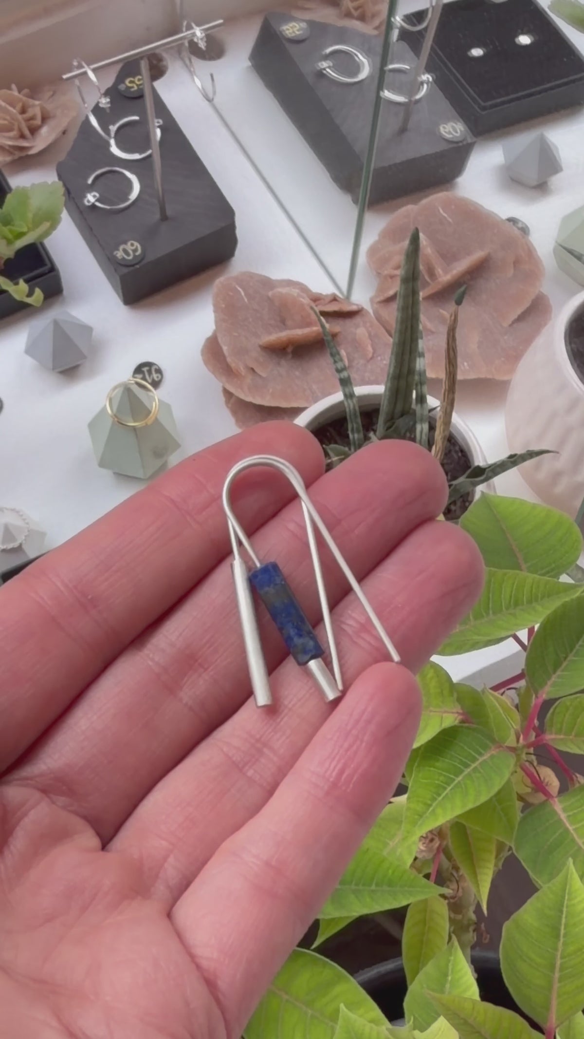 Boucles d’oreilles dépareillées en argent massif 925 et lapis-lazuli, présentées à la main pour montrer leurs détails et leurs proportions.