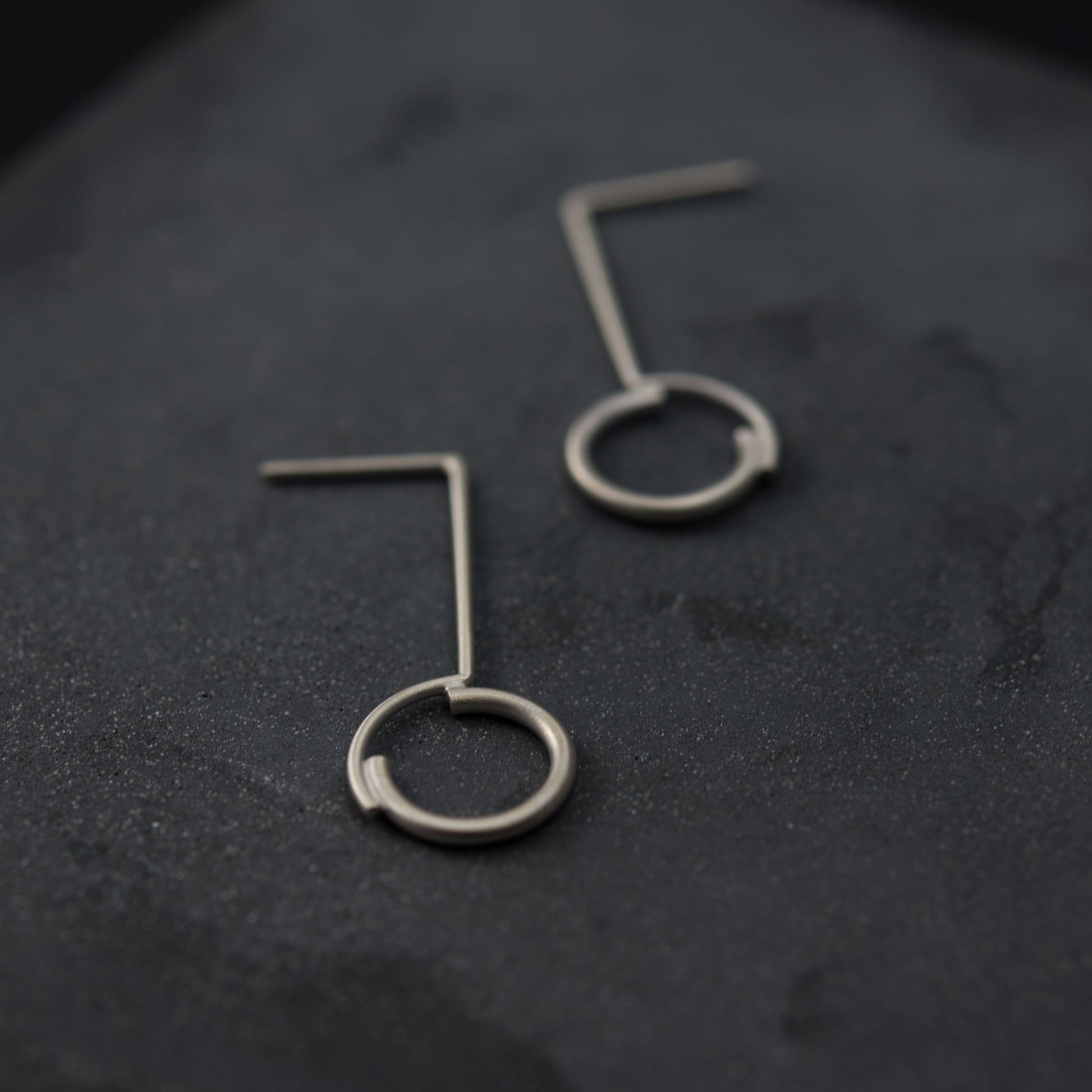 A close up of a circle pendant earrings of 32 millimeters in height 